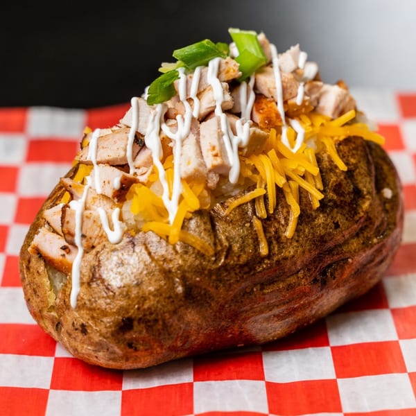 Fat Floyd's Barbecue loaded baked potato with chicken, cheese, sour cream, and green onions.