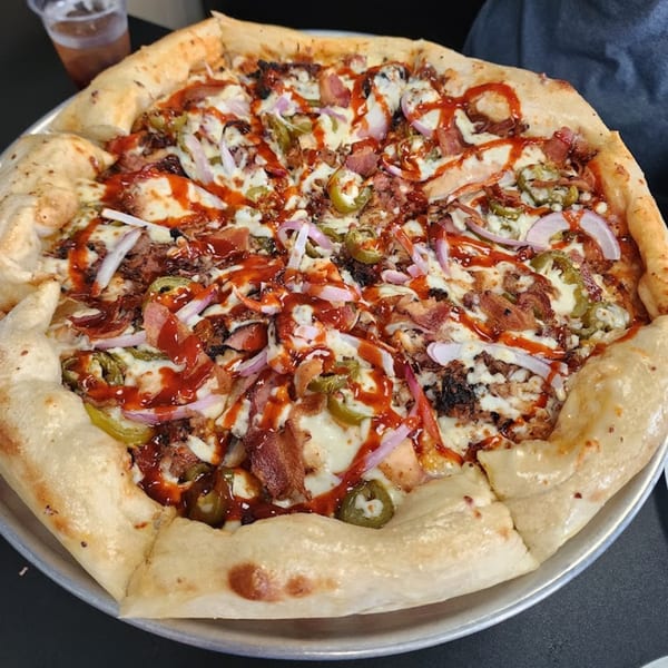 A Fat Floyd's Barbecue pizza topped with pulled pork, bacon, red onion, jalapeños, and BBQ sauce.